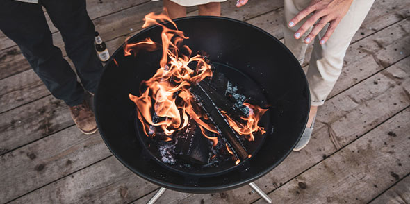 Cuve du brasero Hofats Bowl en acier émaillé avec des bûches allumées