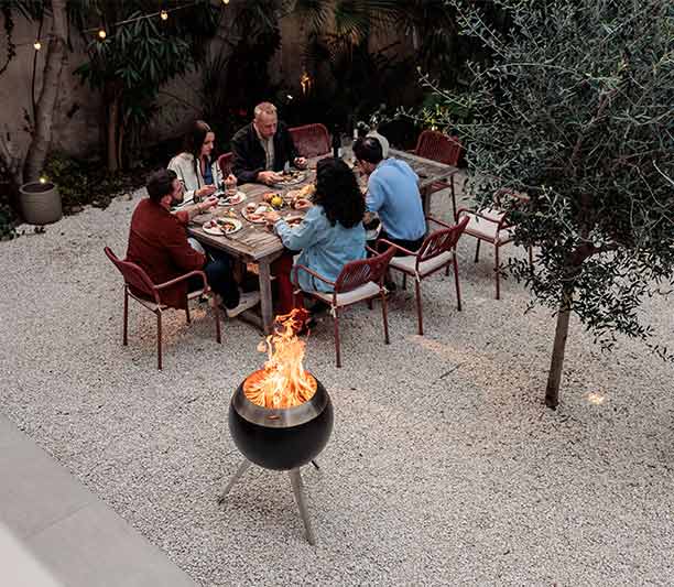 Repas en extérieur avec le brasero Moon 55 Höfats avec pied haut et bas