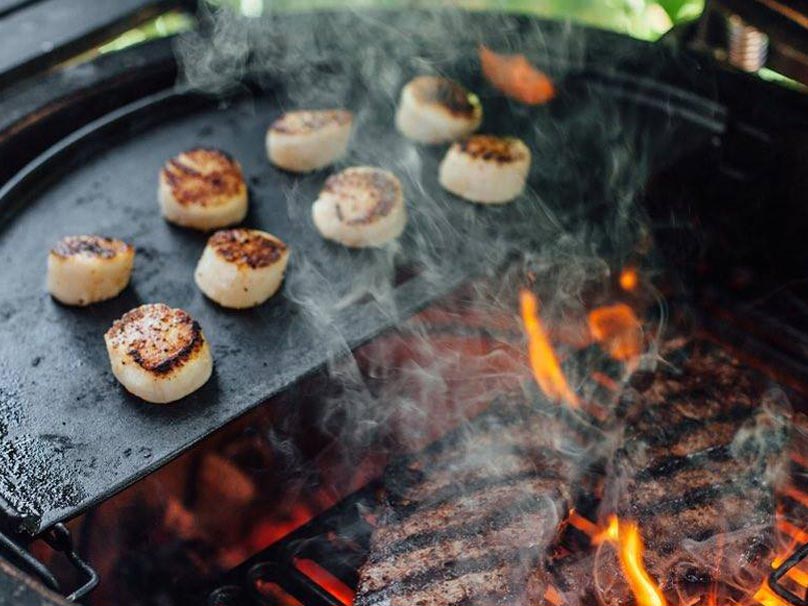 Plancha demi lune en fonte dans le barbecue à charbon Big Joe Kamado Joe