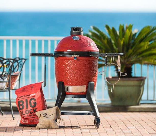 Sac de charbon de bois 9 kg Kamado Joe Big Block XL, posé à côté d'un barbecue kamado
