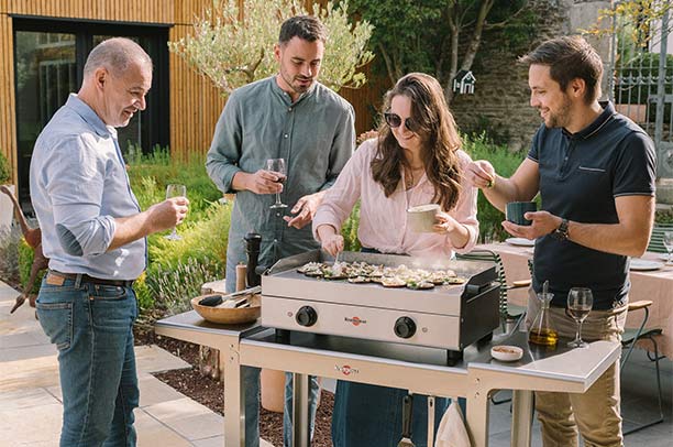 Famille cuisinant autour d'une plancha électrique Saveur 64 cm Krampouz