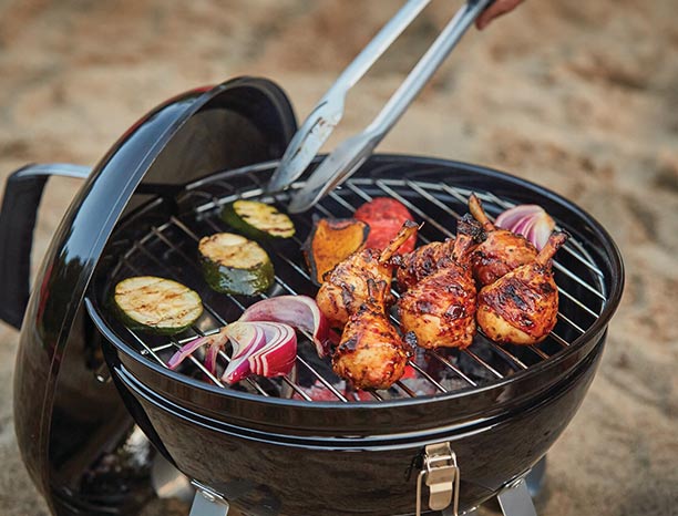 Cuisson d'aliments sur le barbecue Kettle Premium Portable Napoléon