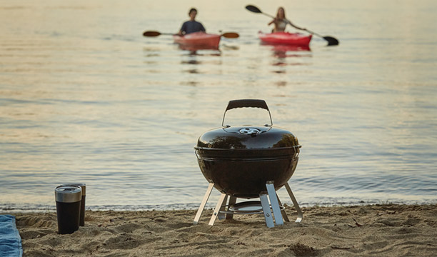 Barbecue Kettle Premium Portable Napoléon posé sur une plage de sable