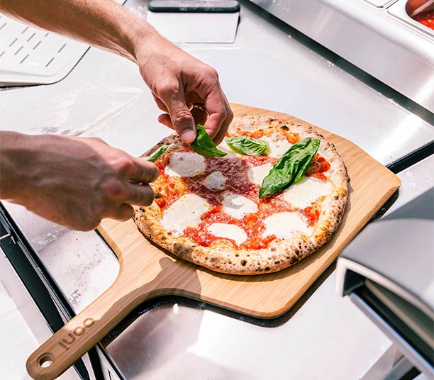 Préparation d'une pizza sur la pelle à pizza en bambou 40 cm d'Ooni