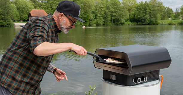 Homme enfournant une pizza dans le four à pizza Prismo 420 G Outdoorchef