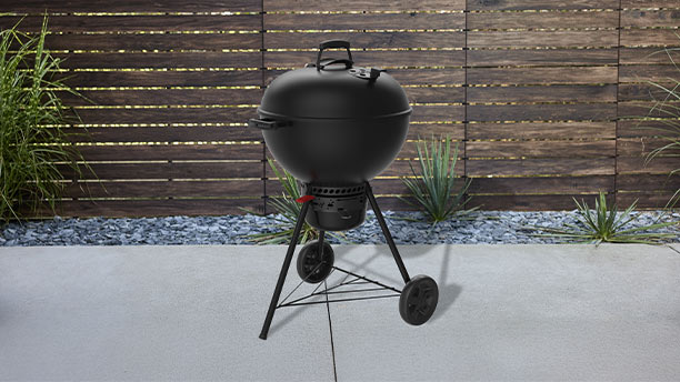 Barbecue charbon Master-Touch 57 cm GBS Stealth Weber sur une terrasse