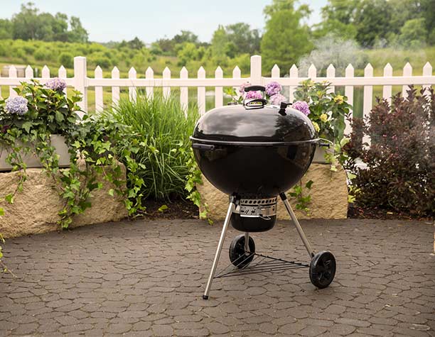 Barbecue charbon Weber Master-Touch Ø 67 cm sur une terrasse