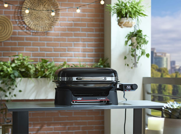 Barbecue électrique Weber Lumin Smart Compact sur un balcon