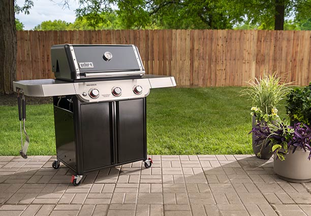 Barbecue gaz Genesis E-315 Weber dans un jardin