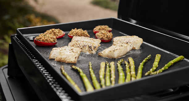 Cuisson d'aliments sur la plaque de cuisson fonte émaillée de la plancha gaz 56 cm Weber